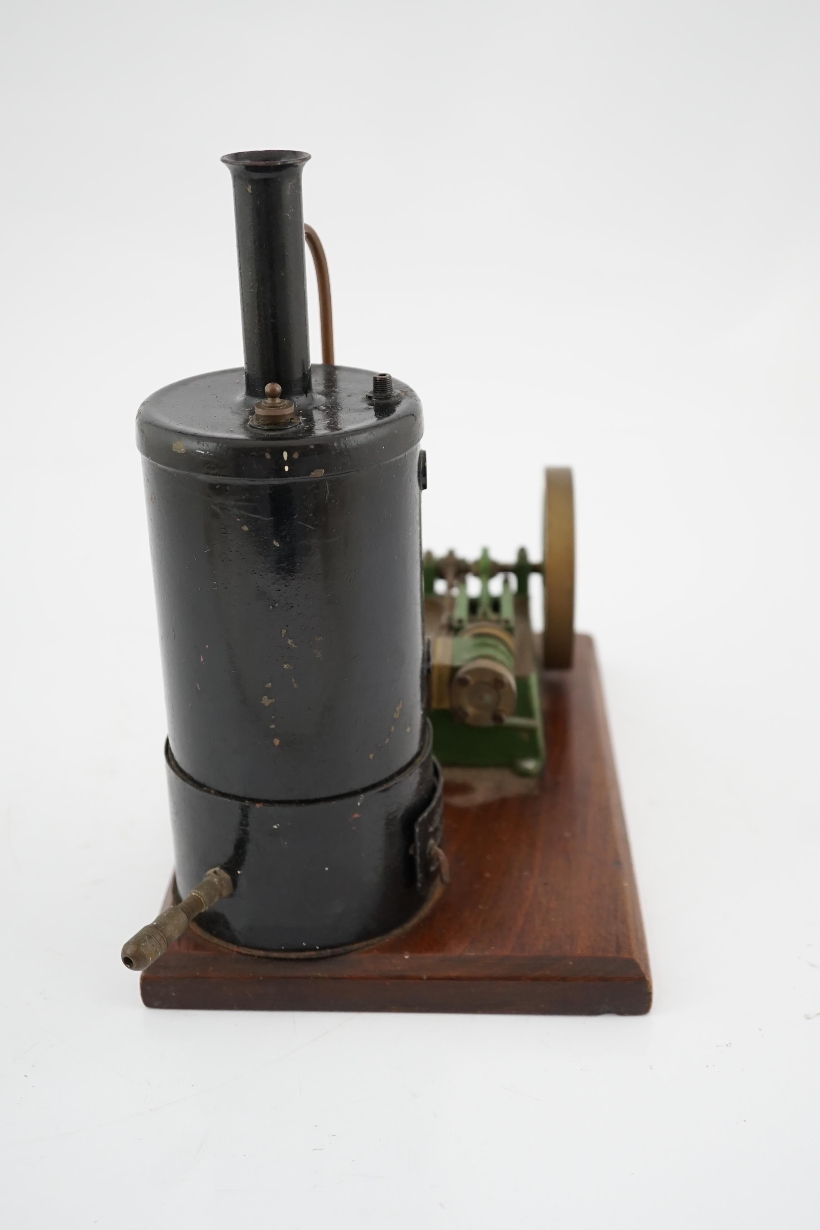 A Stuart Turner style stationary steam plant, with vertical boiler with fittings for a water sight glass and a pressure gauge (both missing), connected to a single cylinder horizontal steam engine with slide valve, mount